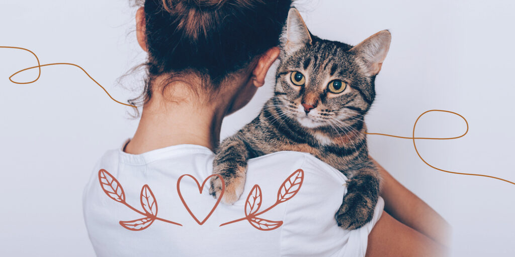 Une femme porte un chat dans ses bras