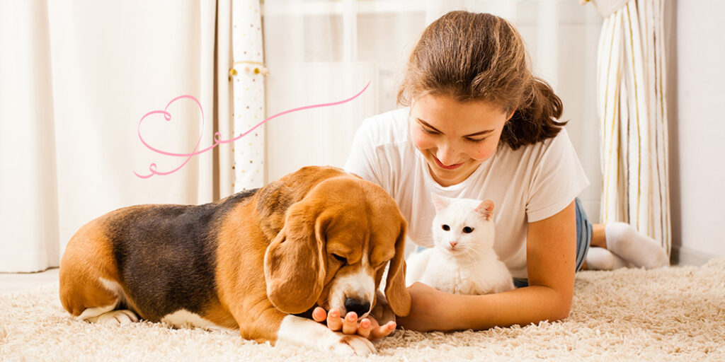 Une fille avec un chat et chien sur un tapis